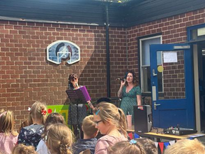 Janine and Shannon leading Harleston Sancroft Academy pupils in songs